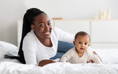 Cute Little African American Baby Crawling In Bed With Mom