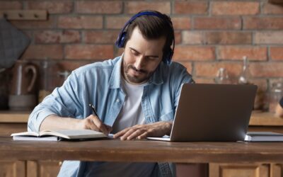Young Caucasian Man Make Notes Working On Laptop
