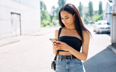 Beautiful Stylish Black Woman Looking At Her Cell Phone Walking