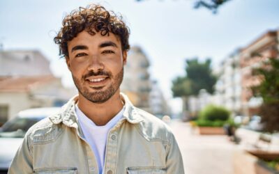 Handsome hispanic man with beard smiling happy outdoors on a sun